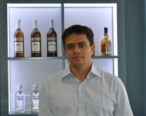 Imagen de Massimiliano Maffioli, director de RR.HH. de Pernod Ricard delante de una selección de botellas de la marca