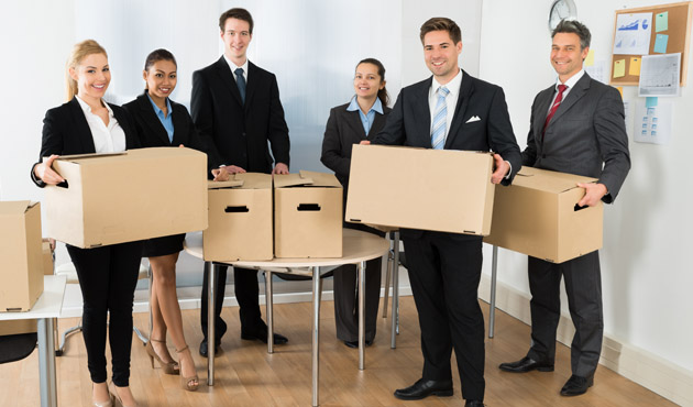Employees In Office Holding Cardboard Boxes