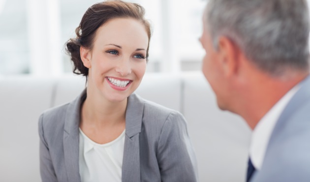 Cheerful businesswoman listening to her workmate talking in bright office