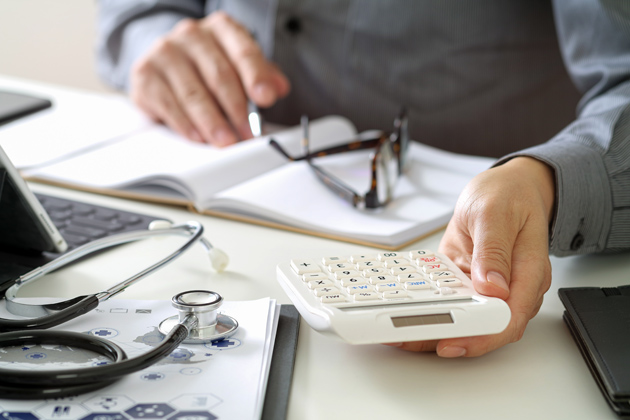 Healthcare costs and fees concept.Hand of smart doctor used a ca