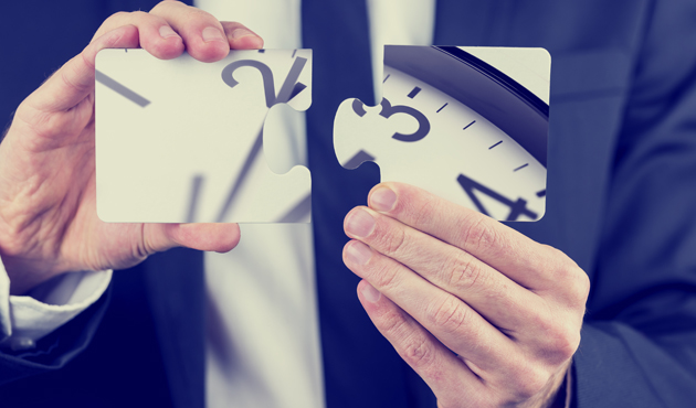 Businessman holding puzzle pieces of a clock